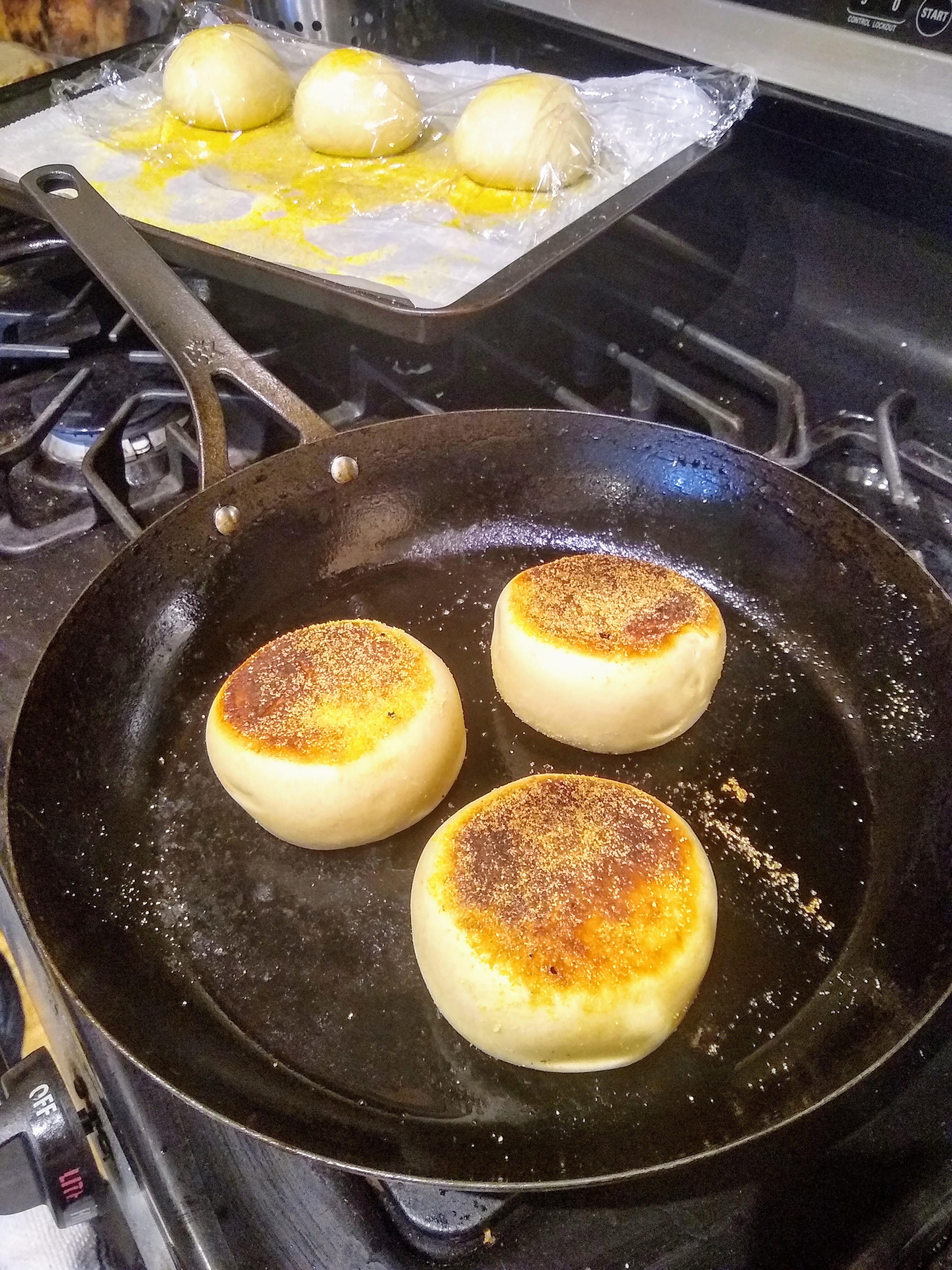 English muffins cooking in a cast iron pan