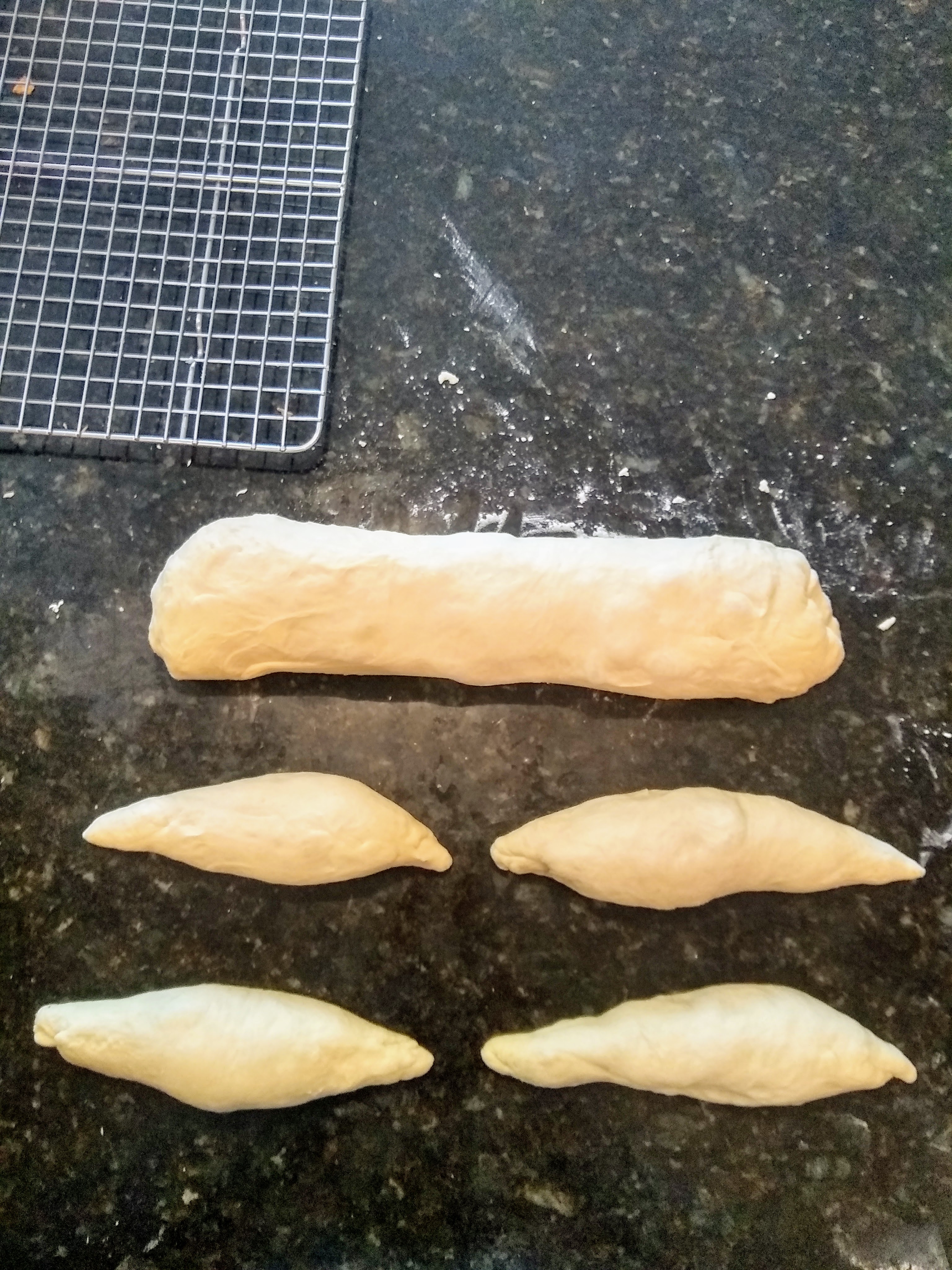 Italian bread, shaped into a large batard and some smaller torpedo rolls