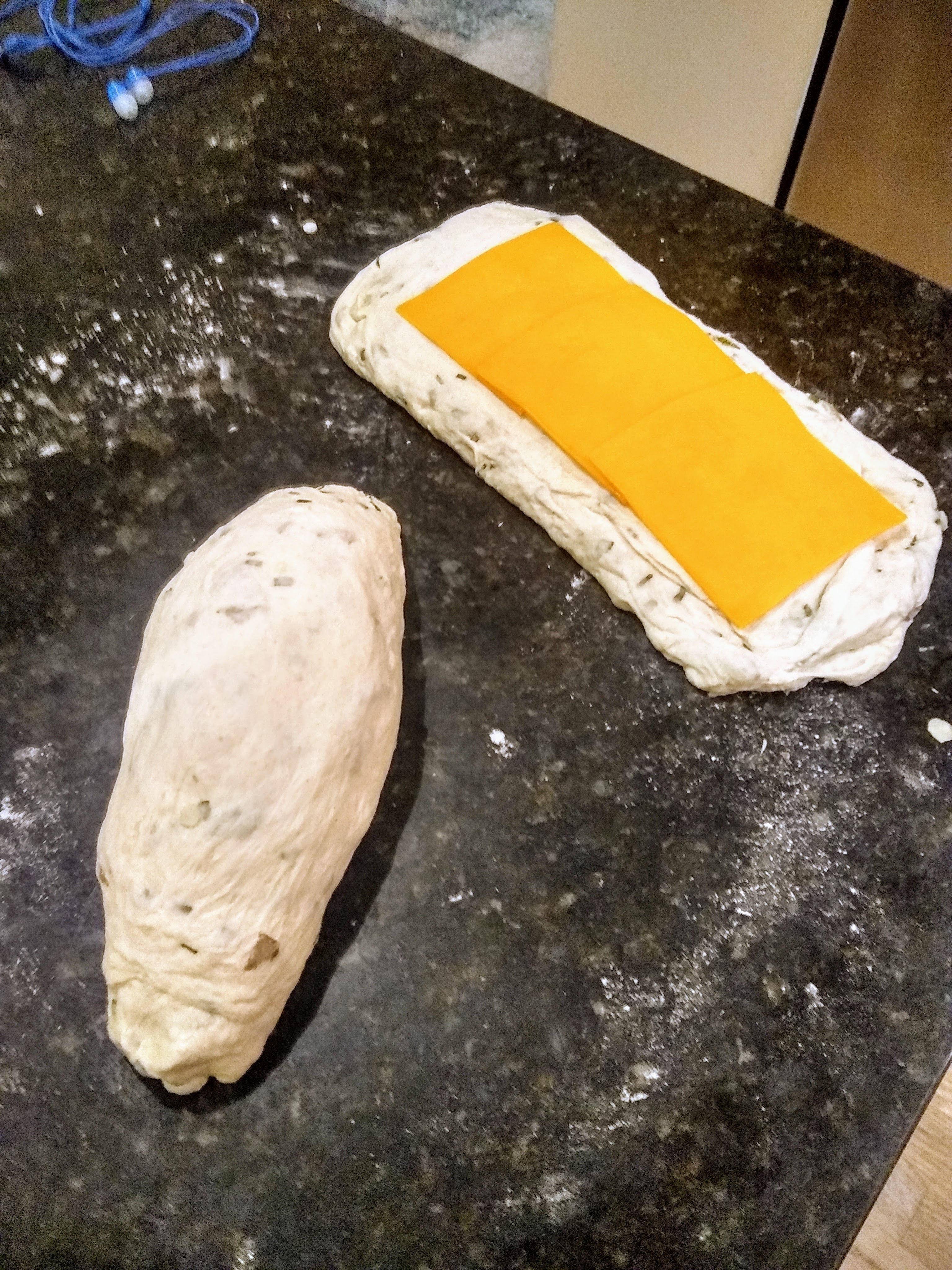 Forming rolls of bread with a spiral of cheese.